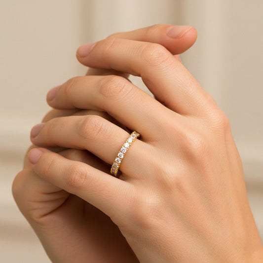 Mano de mujer usando un anillo sin fin en oro amarillo de 18 quilates con Diamantes de color blanco alrededor de Joyería Caracas. 