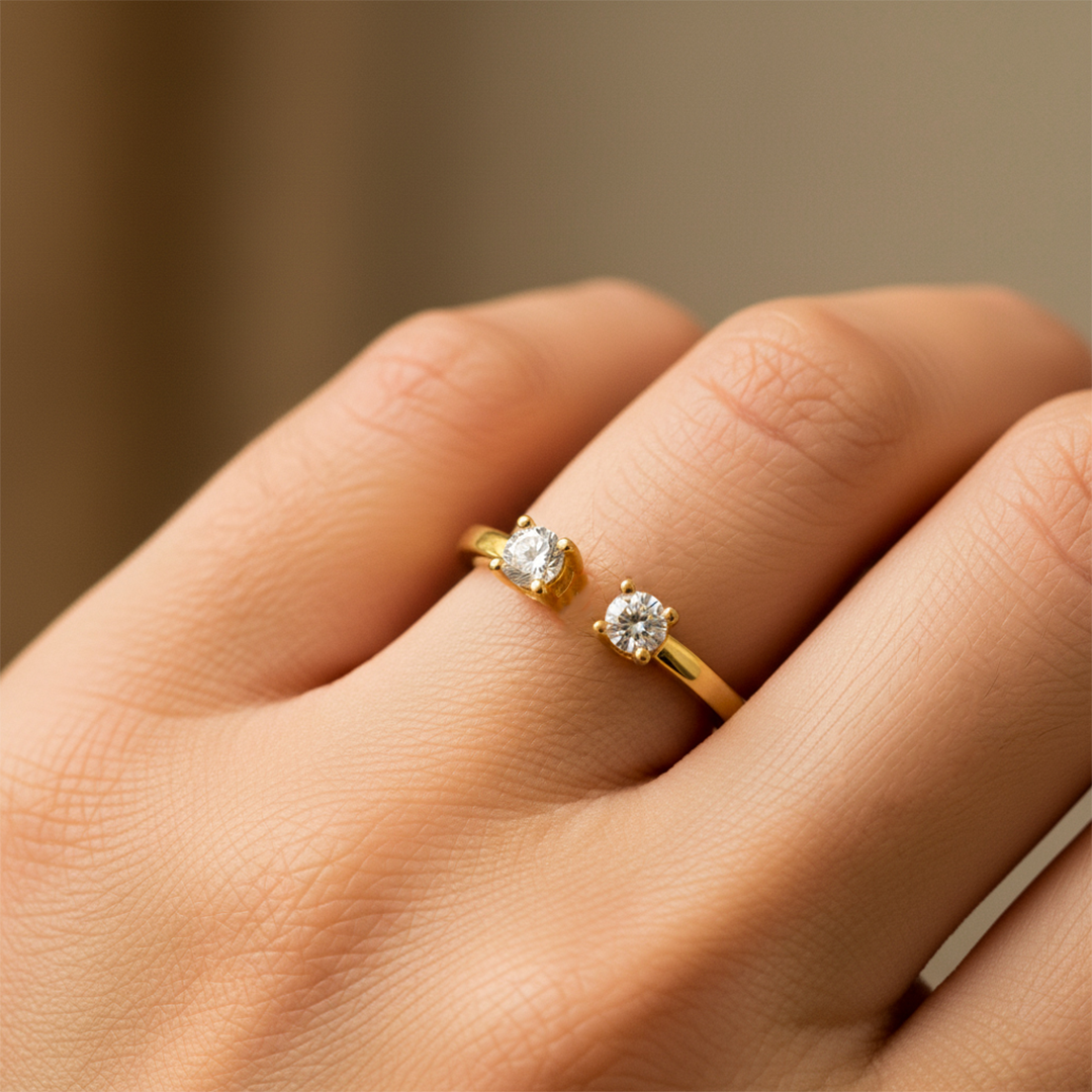 Mano de mujer usando un anillo en oro amarillo de 18 quilates con 2 cristales de color blanco de Joyería Caracas. 