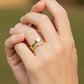 Mano de modelo usando un anillo con pisargolla en oro amarillo de 18 quilates con cristales de Joyería Caracas. 