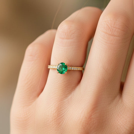 Mano de modelo usando un anillo en oro amarillo de 18 quilates con Esmeralda y cristales de Joyería Caracas. 