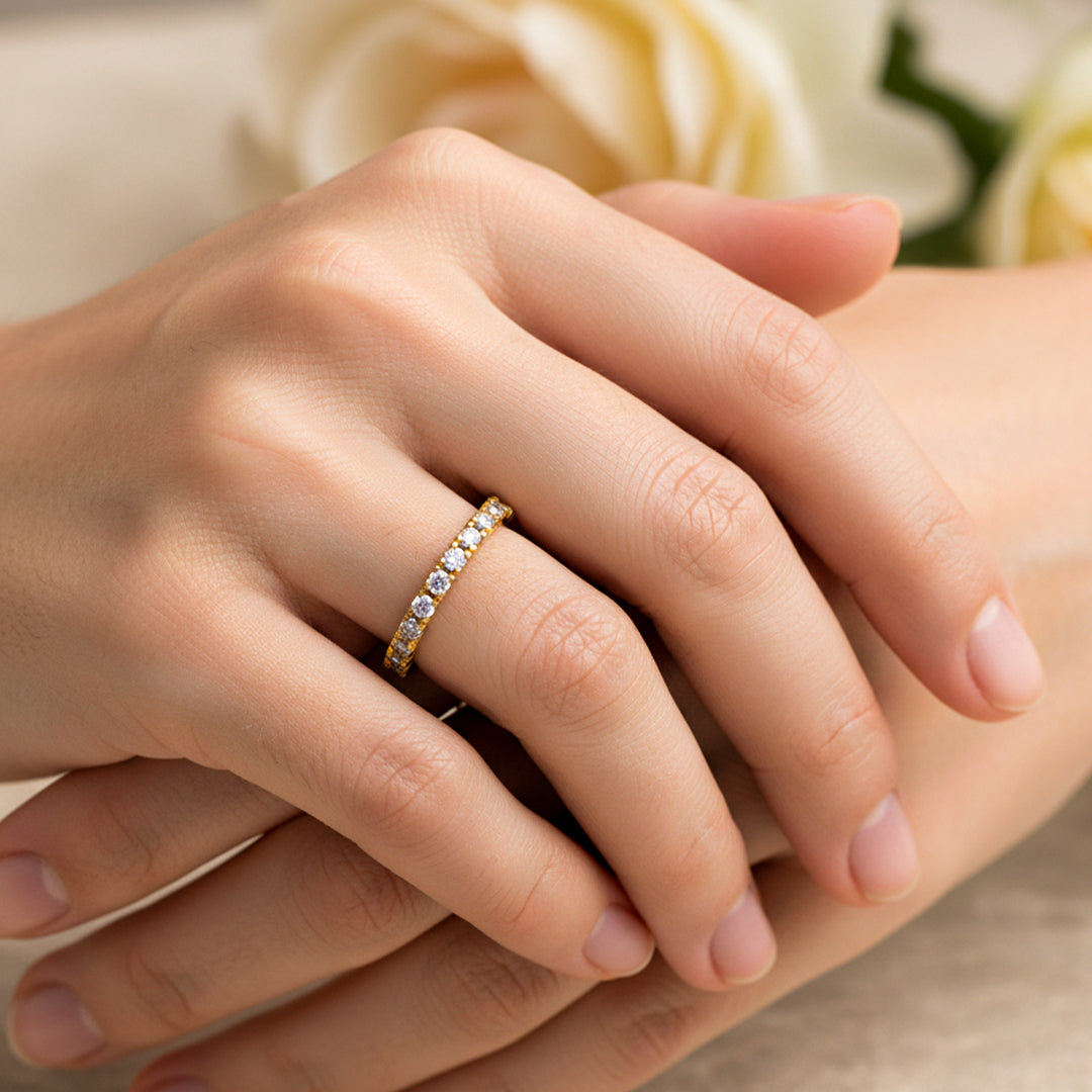 Mano de mujer usando un anillo sin fin en oro amarillo de 18 quilates con Diamantes alrededor de color blanco de Joyería Caracas. 