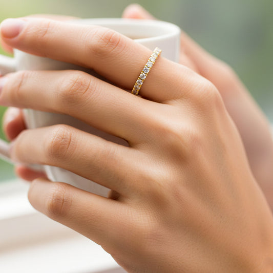 Mano de mujer usando un anillo sin fin en oro amarillo de 18 quilates con Diamantes de color blanco de Joyería Caracas. 