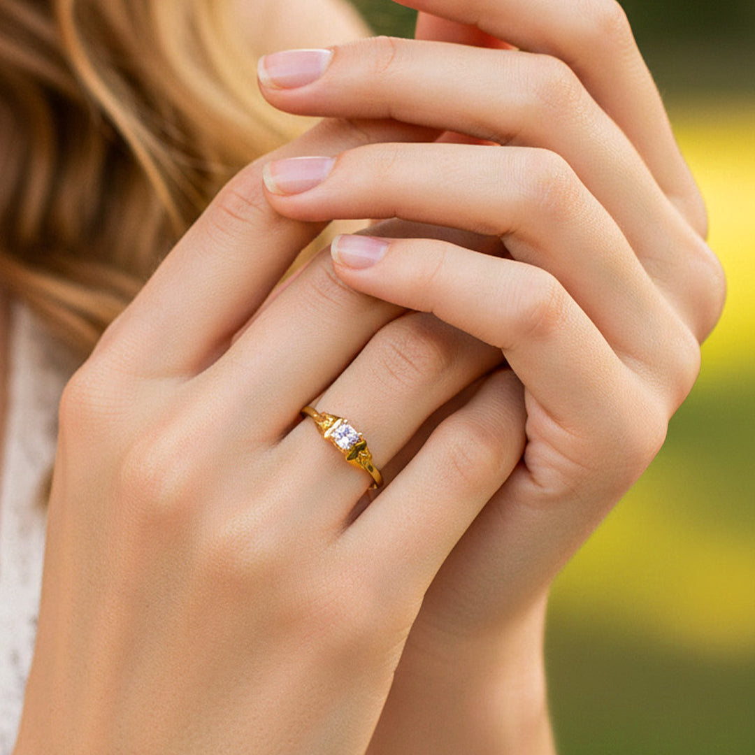 Mano de modelo usando un anillo en oro amarillo de 18 quilates con cristal de Joyería Caracas. 