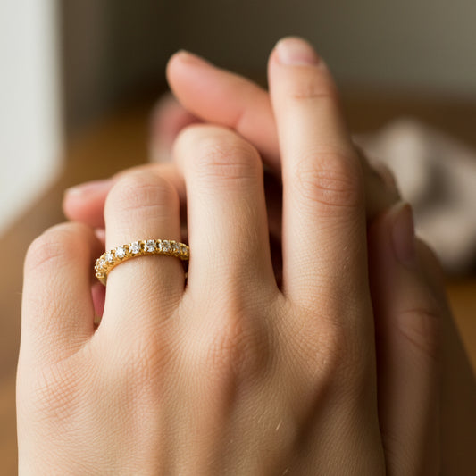 Mano de mujer usando un anillo en oro amarillo de 18 quilates con Diamantes de color blanco de Joyería Caracas. 