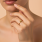 Mano de mujer usando un anillo con forma de flor en el centro en oro amarillo de 18 quilates de Joyería Caracas. 
