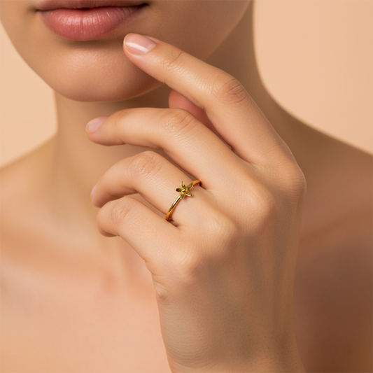 Mano de mujer usando un anillo con forma de flor en el centro en oro amarillo de 18 quilates de Joyería Caracas. 