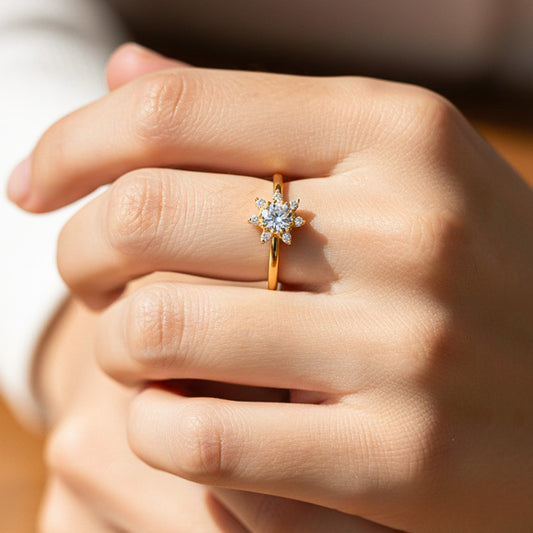 Mano de modelo usando un anillo con forma de flor en oro amarillo de 18 quilates con cristales de Joyería Caracas. 