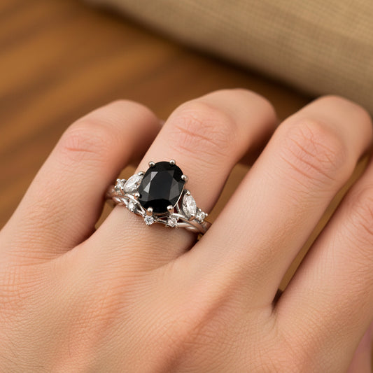 Mano de mujer usando un anillo en oro blanco de 18 quilates con Zafiro central natural y cristales de color blanco alrededor de Joyería Caracas. 