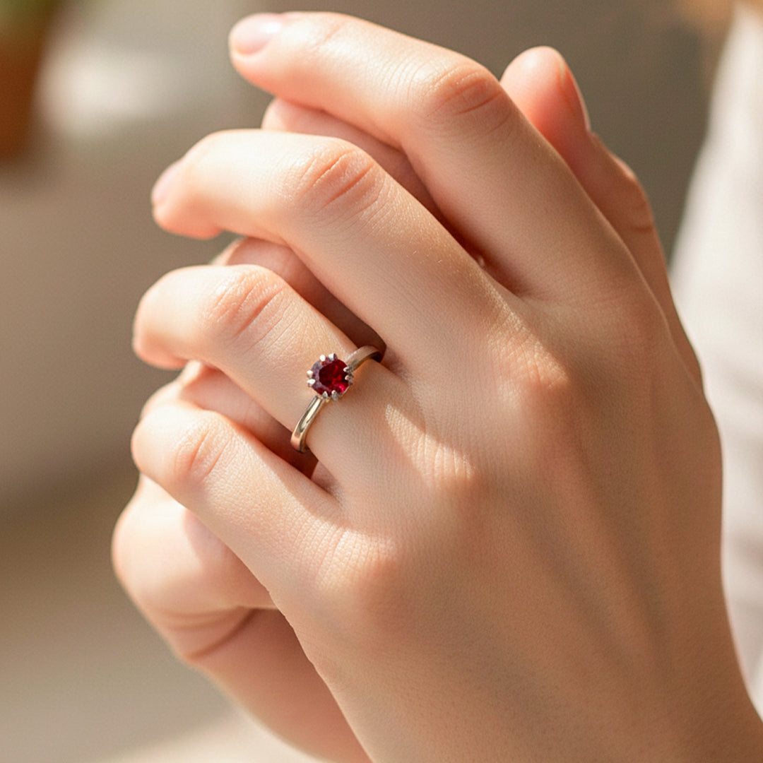 Mano de modelo usando un anillo en oro blanco de 18 quilates con piedra sintética Rubí de Joyería Caracas. 