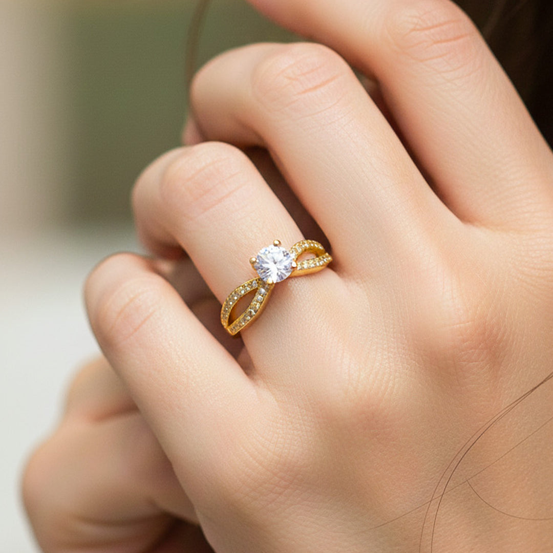 Mano de modelo usando un anillo con diseño de infinito en oro amarillo de 18 quilates con cristales de Joyería Caracas. 