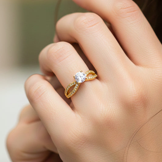 Mano de modelo usando un anillo con diseño de infinito en oro amarillo de 18 quilates con cristales de Joyería Caracas. 