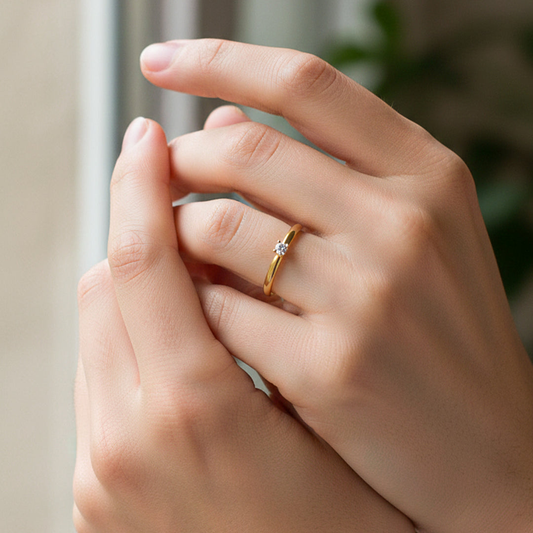 Mano de modelo usando un anillo en oro amarillo de 18 quilates solitario con cristal de Joyería Caracas. 