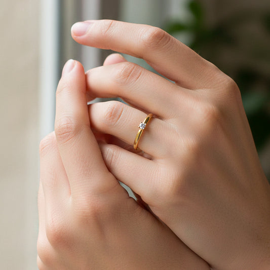 Mano de modelo usando un anillo en oro amarillo de 18 quilates solitario con cristal de Joyería Caracas. 