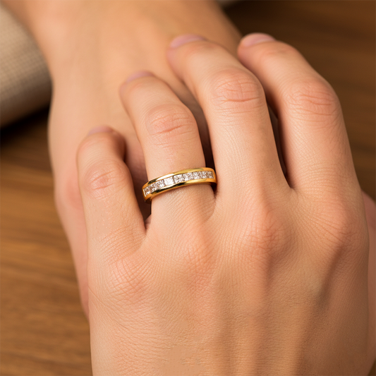 Mano de mujer usando un anillo en oro amarillo de 18 quilates con cristales cuadrados de color blanco de Joyería Caracas. 