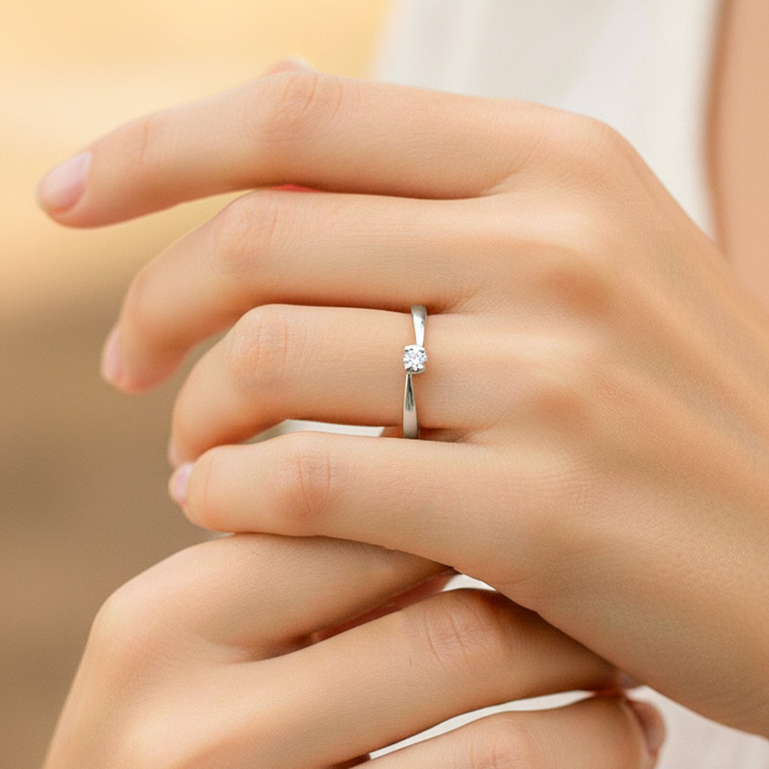 Mano de modelo usando un anillo solitario en oro blanco de 18 quilates con cristal de Joyería Caracas.