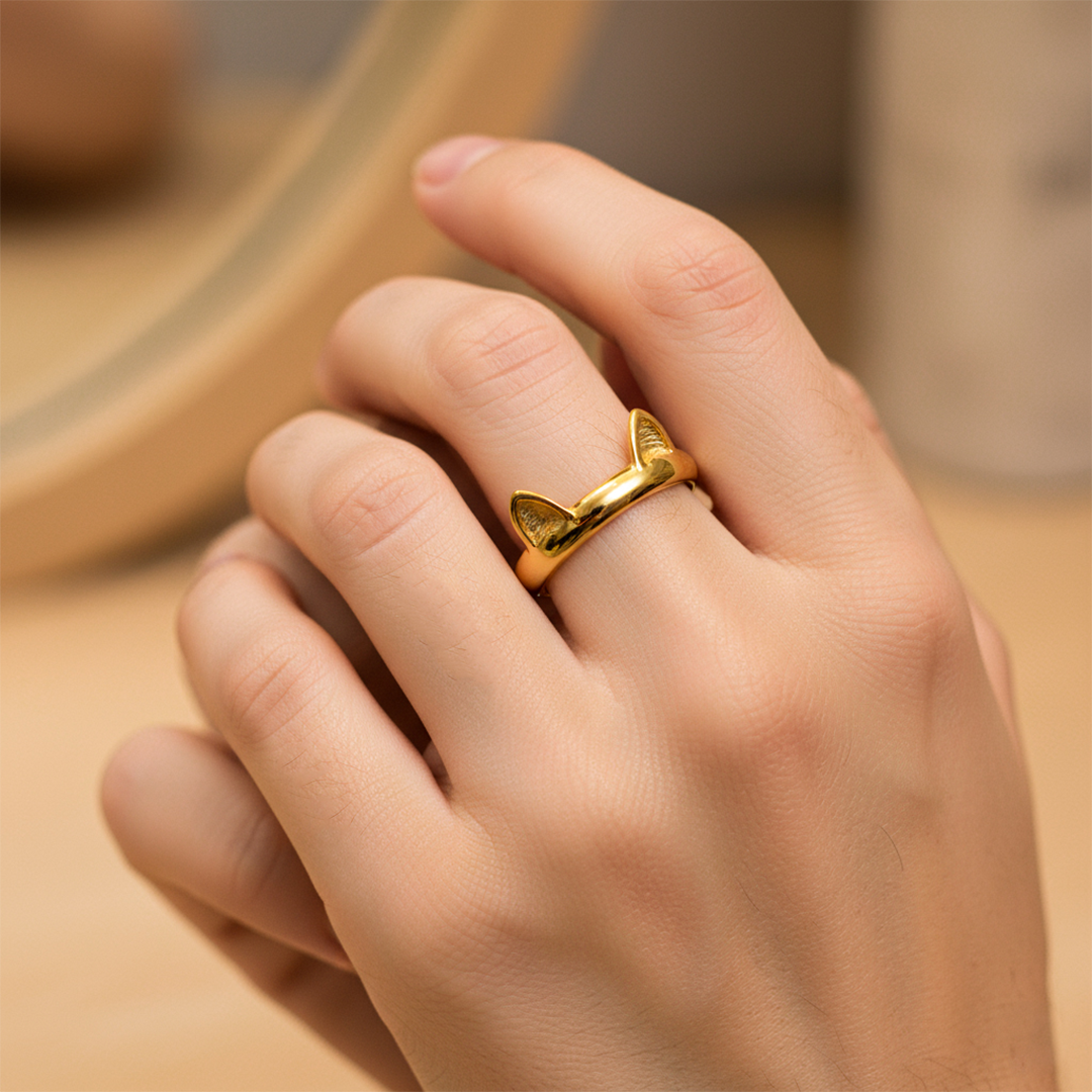 Mano de mujer usando un anillo con orejitas de gato en oro amarillo de 18 quilates de Joyería Caracas. 