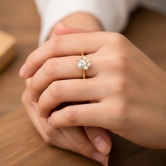 Mano de mujer usando un anillo con la forma de patica de cachorro en oro amarillo de 18 quilates con cristales de color blanco de Joyería Caracas. 