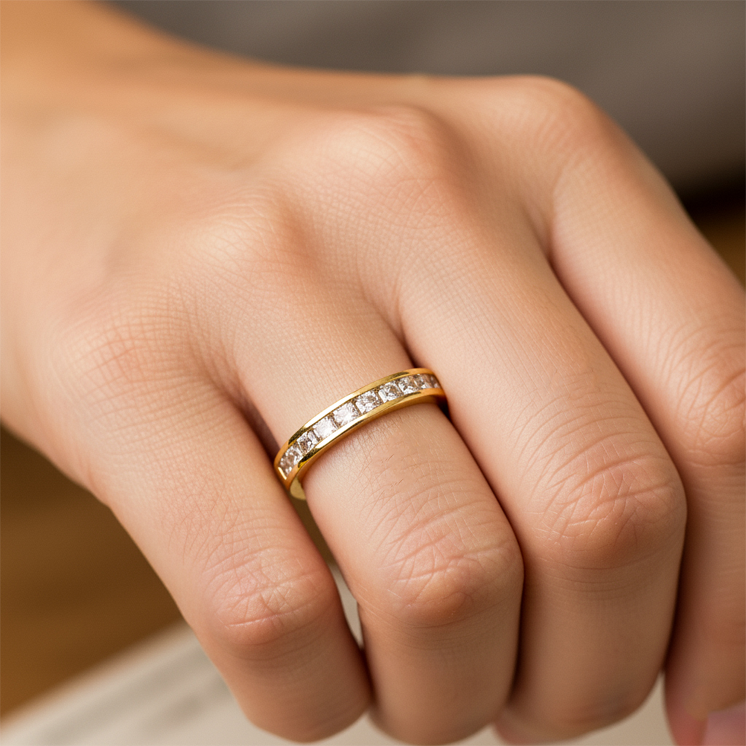 Mano de mujer usando un anillo en oro blanco de 18 quilates con cristales cuadrados de color blanco de Joyería Caracas. 