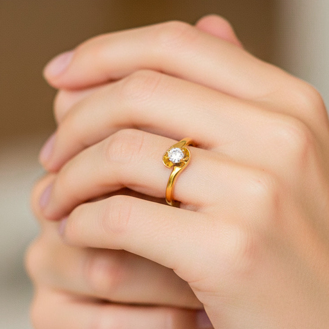 Mano de modelo usando un anillo con forma de pétalo en oro amarillo de 18 quilates con cristal de Joyería Caracas. 