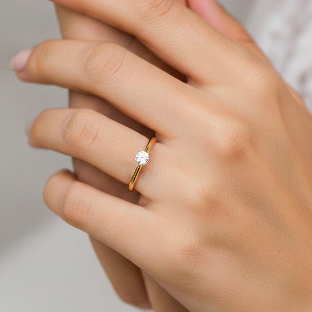 Mano de modelo usando un anillo en oro amarillo de 18 quilates con Moissanite de Joyería Caracas. 