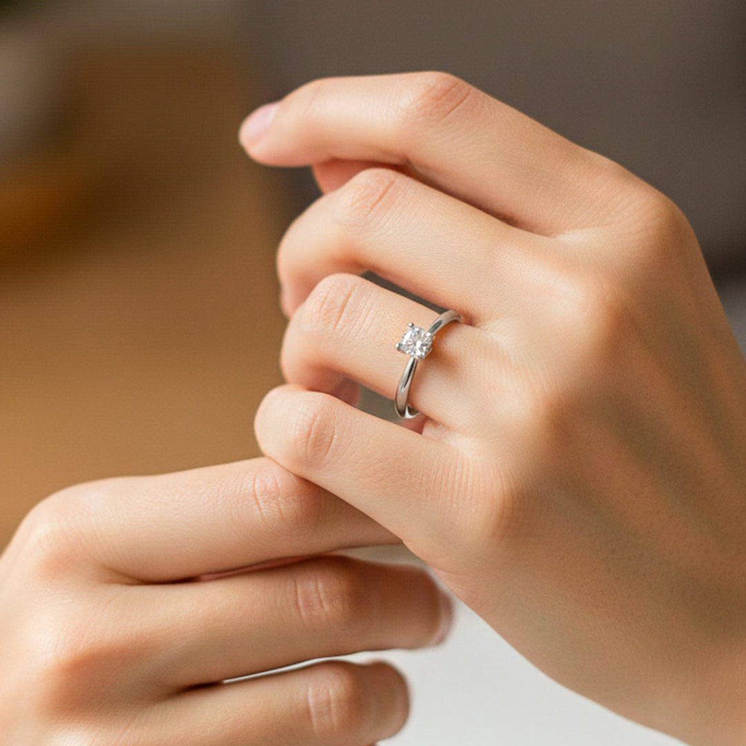 Mano de modelo usando un anillo en oro blanco de 18 quilates con cristal blanco de Joyería Caracas. 