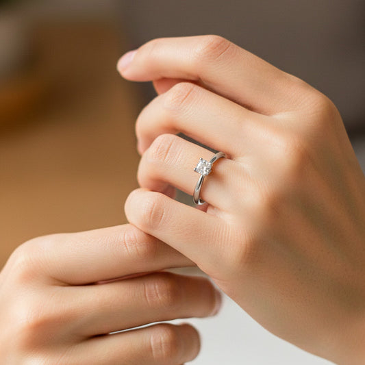 Mano de modelo usando un anillo en oro blanco de 18 quilates con cristal blanco de Joyería Caracas. 