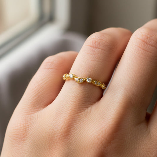 Mano de mujer usando un anillo pisargolla en oro amarillo de 18 quilates con cristales de color blanco de Joyería Caracas. 
