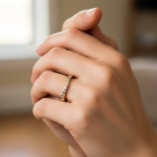 Mano de mujer usando un anillo pisargolla en oro amarillo de 18 quilates con cristales de color blanco de Joyería Caracas. 
