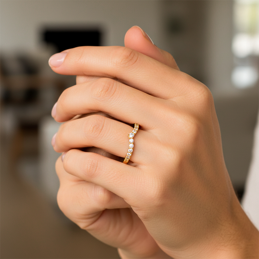 Mano de mujer usando un anillo con forma en la punta en oro amarillo de 18 quilates y Diamantes alrededor de color blanco de Joyería Caracas. 