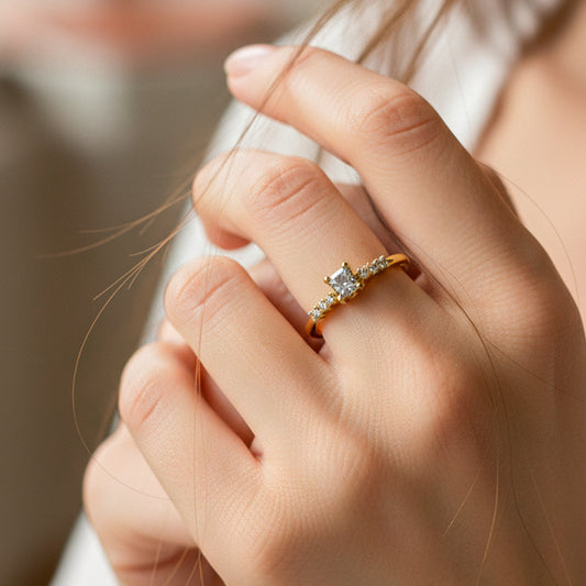 Mano de mujer con anillo en oro amarillo de 18 quilates con Diamante central y laterales en color blanco, hecho en Joyería Caracas. 
