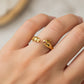 Mano de mujer usando un anillo con forma de conejo y zanahoria en oro amarillo de 18 quilates de Joyería Caracas. 