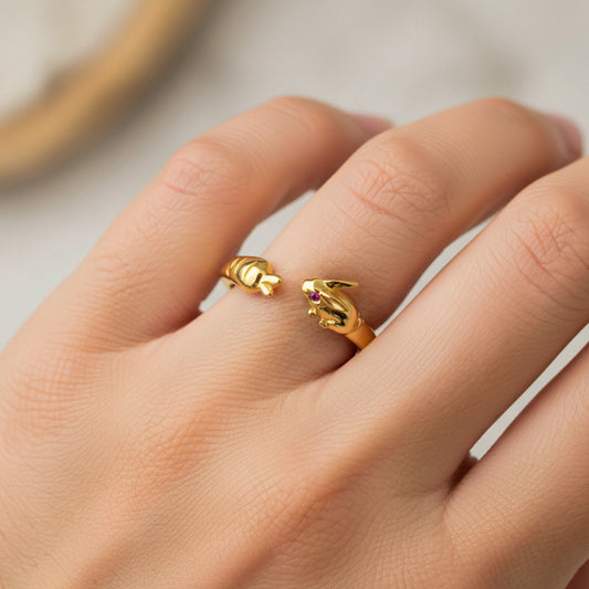 Mano de mujer usando un anillo con forma de conejo y zanahoria en oro amarillo de 18 quilates de Joyería Caracas. 