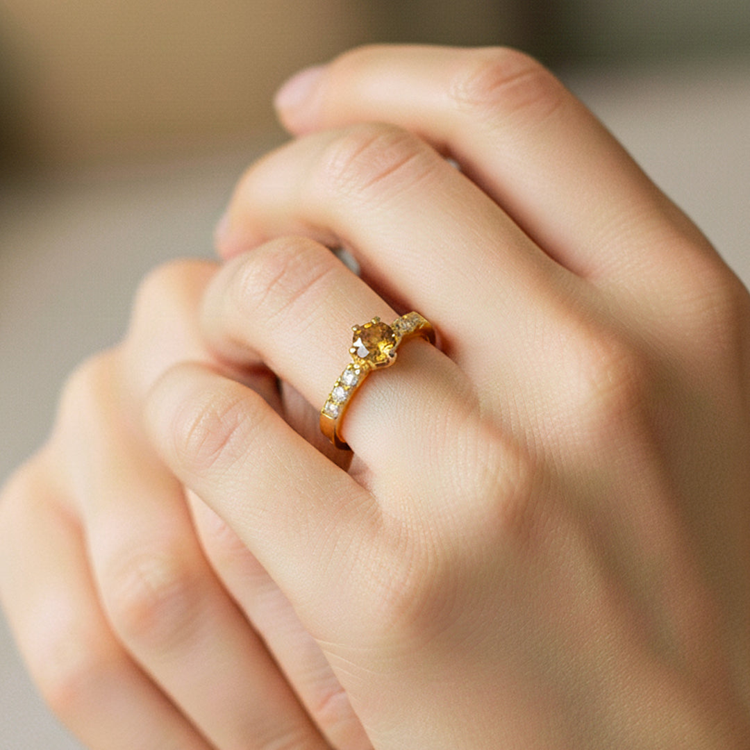 Mano de modelo usando un anillo en oro amarillo de 18 quilates con cristales de Joyería Caracas.