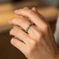 Mano de mujer usando un anillo en oro amarillo de 18 quilates con Esmeralda rectangular de Joyería Caracas. 