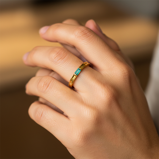 Mano de mujer usando un anillo en oro amarillo de 18 quilates con Esmeralda rectangular de Joyería Caracas. 