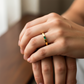 Mano de mujer usando un anillo en oro amarillo de 18 quilates con Esmeralda en el centro en forma rectangular de Joyería Caracas. 