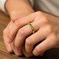 Mano de mujer usando un anillo en oro amarillo de 18 quilates con Esmeralda en el centro rectangular de Joyería Caracas. 