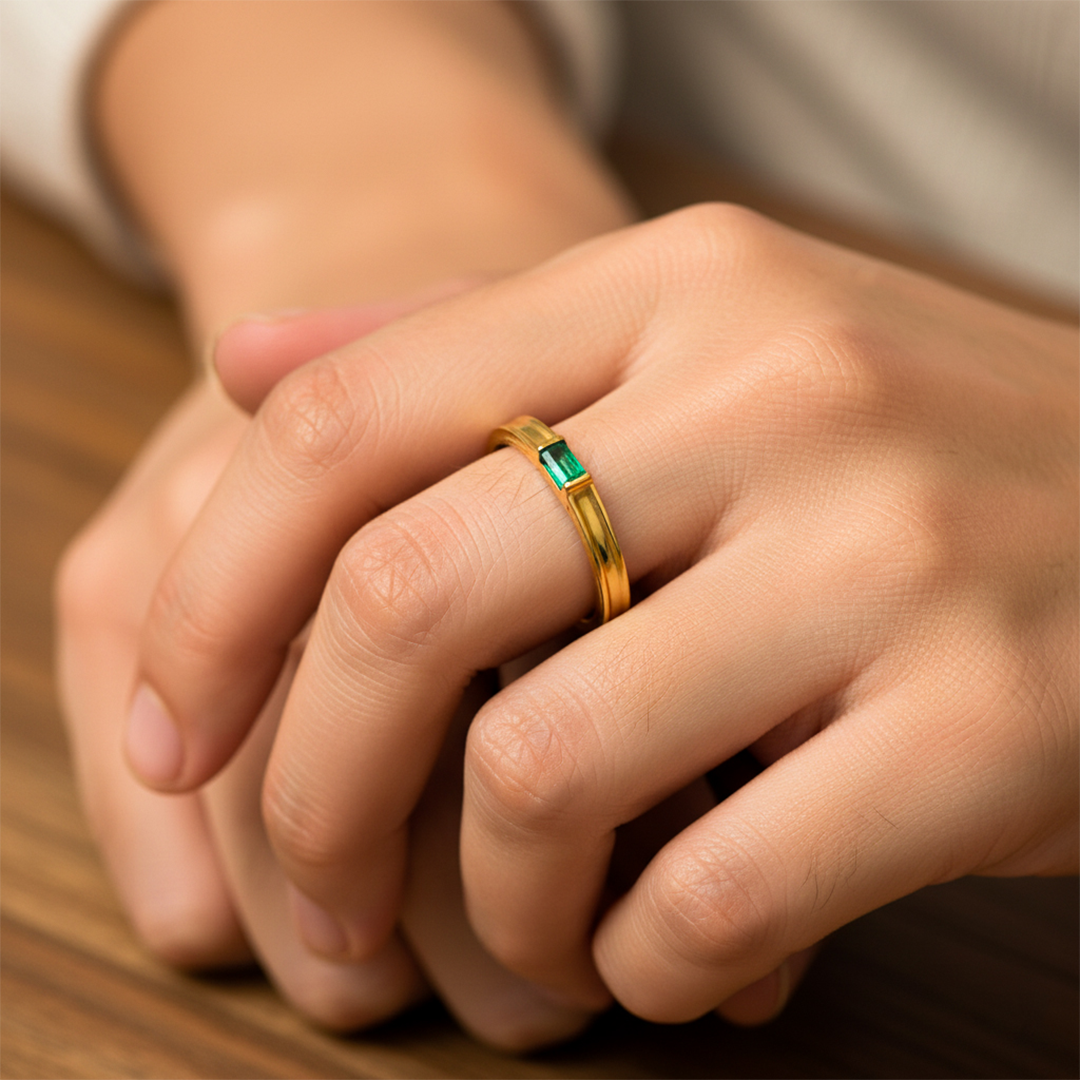 Mano de mujer usando un anillo en oro amarillo de 18 quilates con Esmeralda en el centro rectangular de Joyería Caracas. 