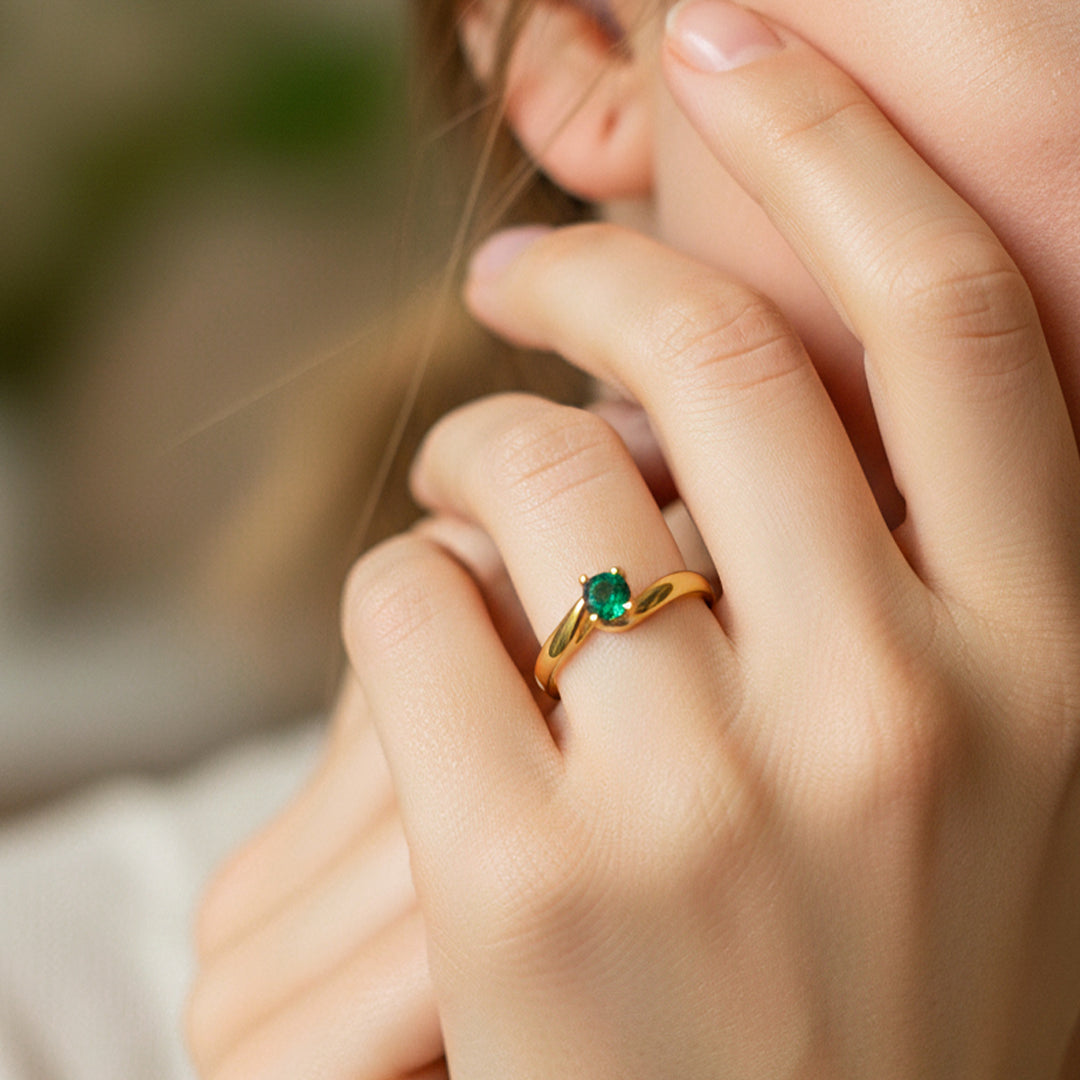 Mano de modelo usando un anillo en oro amarillo de 18 quilates con cristal verde de Joyería Caracas. 