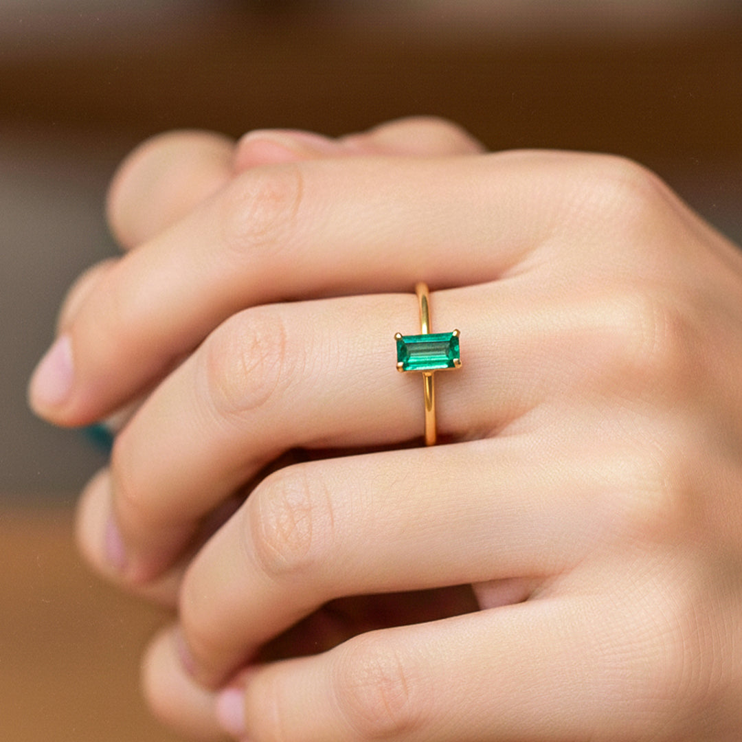 Mano de modelo usando un anillo en oro amarillo de 18 quilates con Esmeralda en corte baguette de Joyería Caracas. 