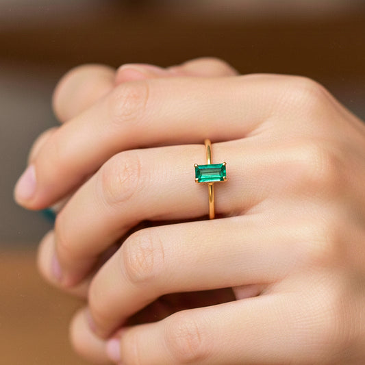 Mano de modelo usando un anillo en oro amarillo de 18 quilates con Esmeralda en corte baguette de Joyería Caracas. 