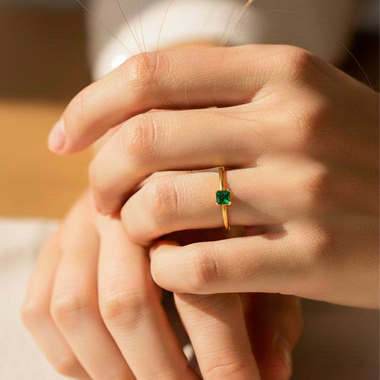 Mano de modelo usando un anillo en oro amarillo de 18 quilates con cristal cuadrado de Joyería Caracas. 