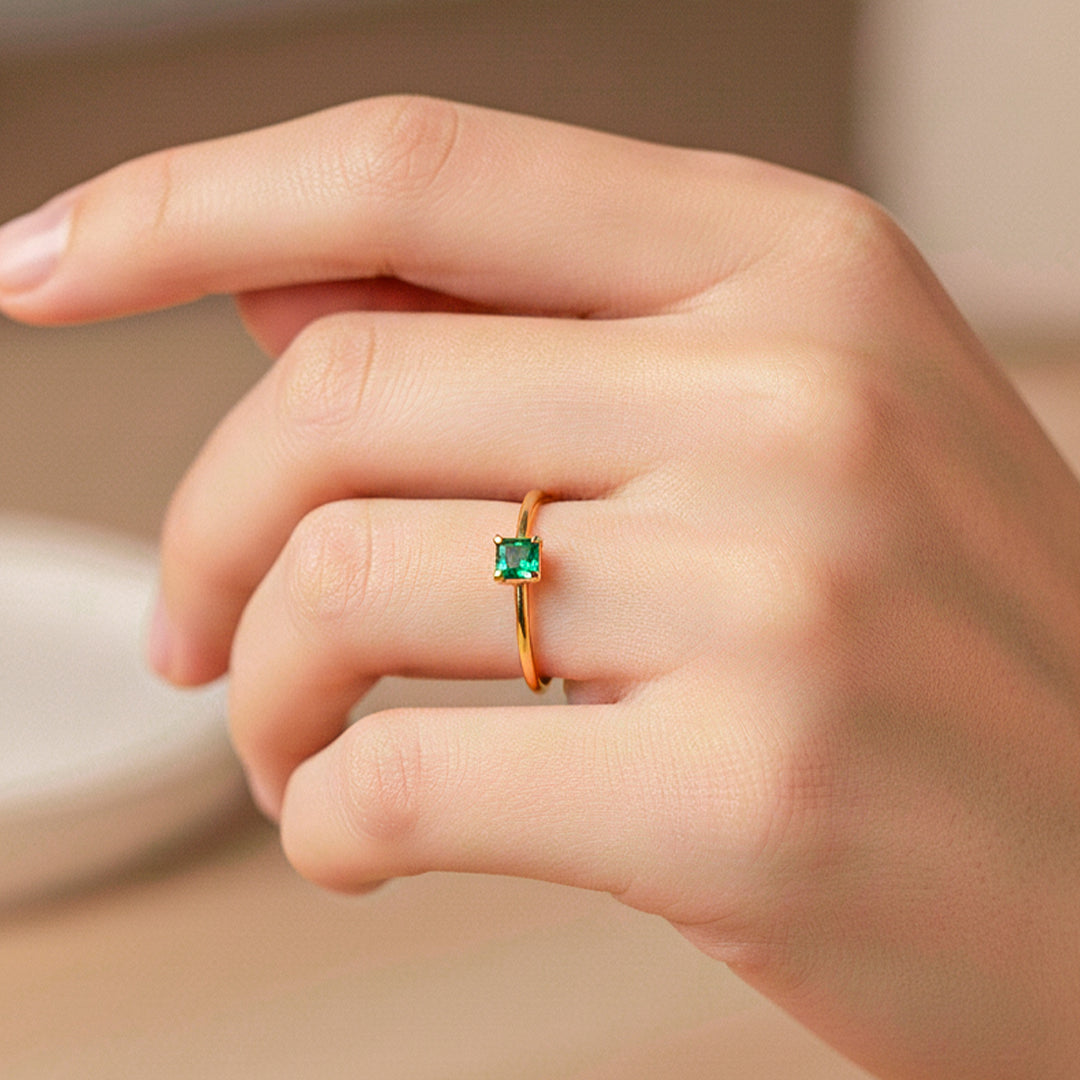 Mano de modelo usando un anillo en oro amarillo de 18 quilates con Esmeralda de Joyería Caracas. 