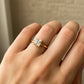 Mano de mujer usando un anillo en oro amarillo de 18 quilates con cristal cuadrado en el centro de color blanco de Joyería Caracas. 