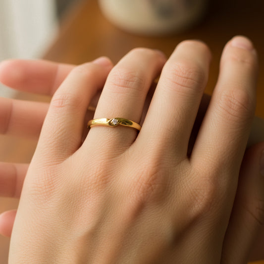 Mano de mujer usando un anillo en oro amarillo de 18 quilates con 1 cristal en el centro de Joyería Caracas.