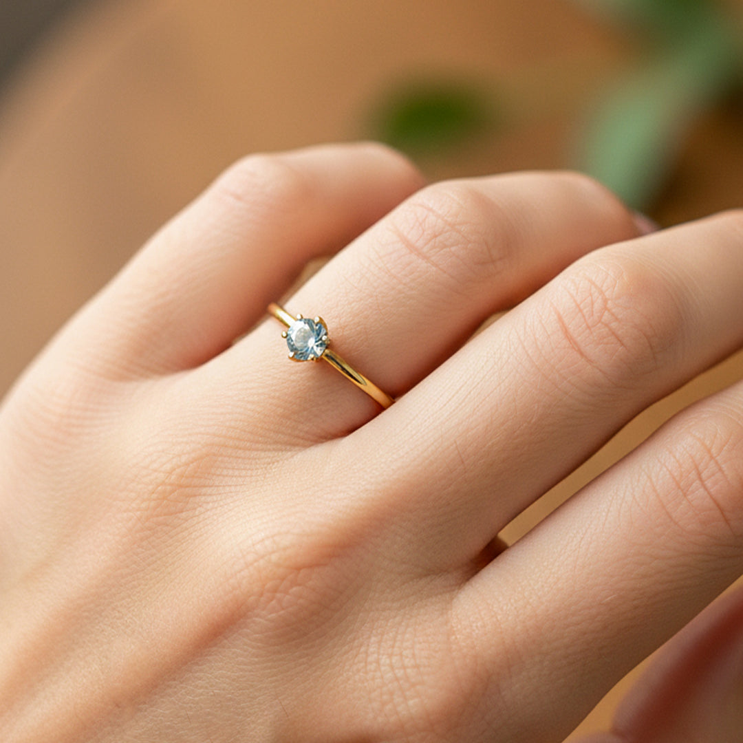 Mano de modelo usando un anillo solitario en oro amarillo de 18 quilates con cristal de Joyería Caracas. 