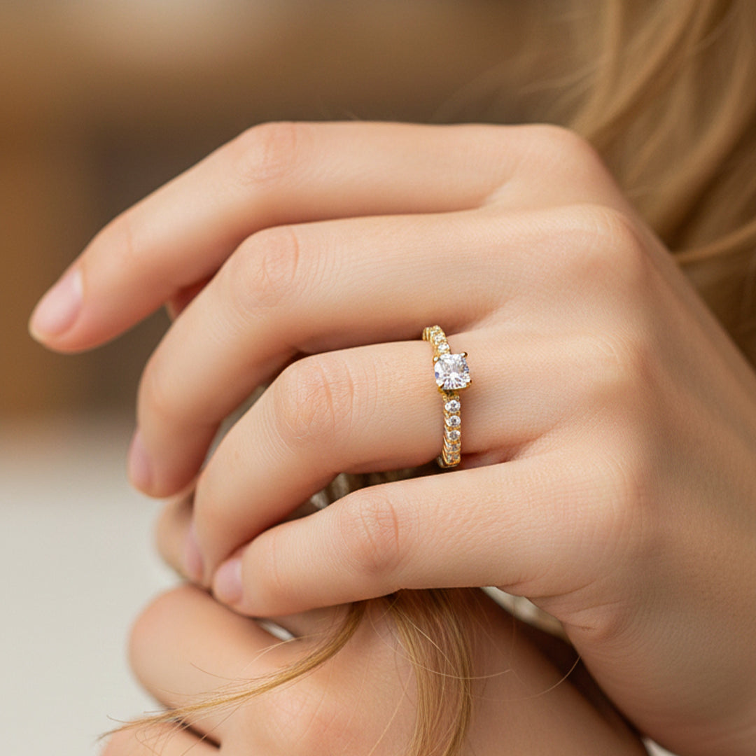 Mano de modelo usando un anillo solitario en oro amarillo de 18 quilates con cristales de Joyería Caracas. 