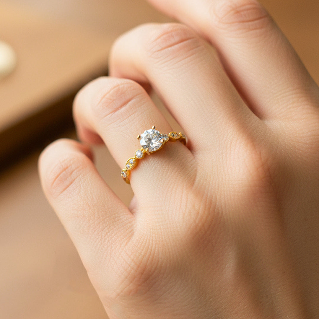 Mano de modelo usando un anillo solitario en oro amarillo de 18 quilates con cristales de Joyería Caracas. 