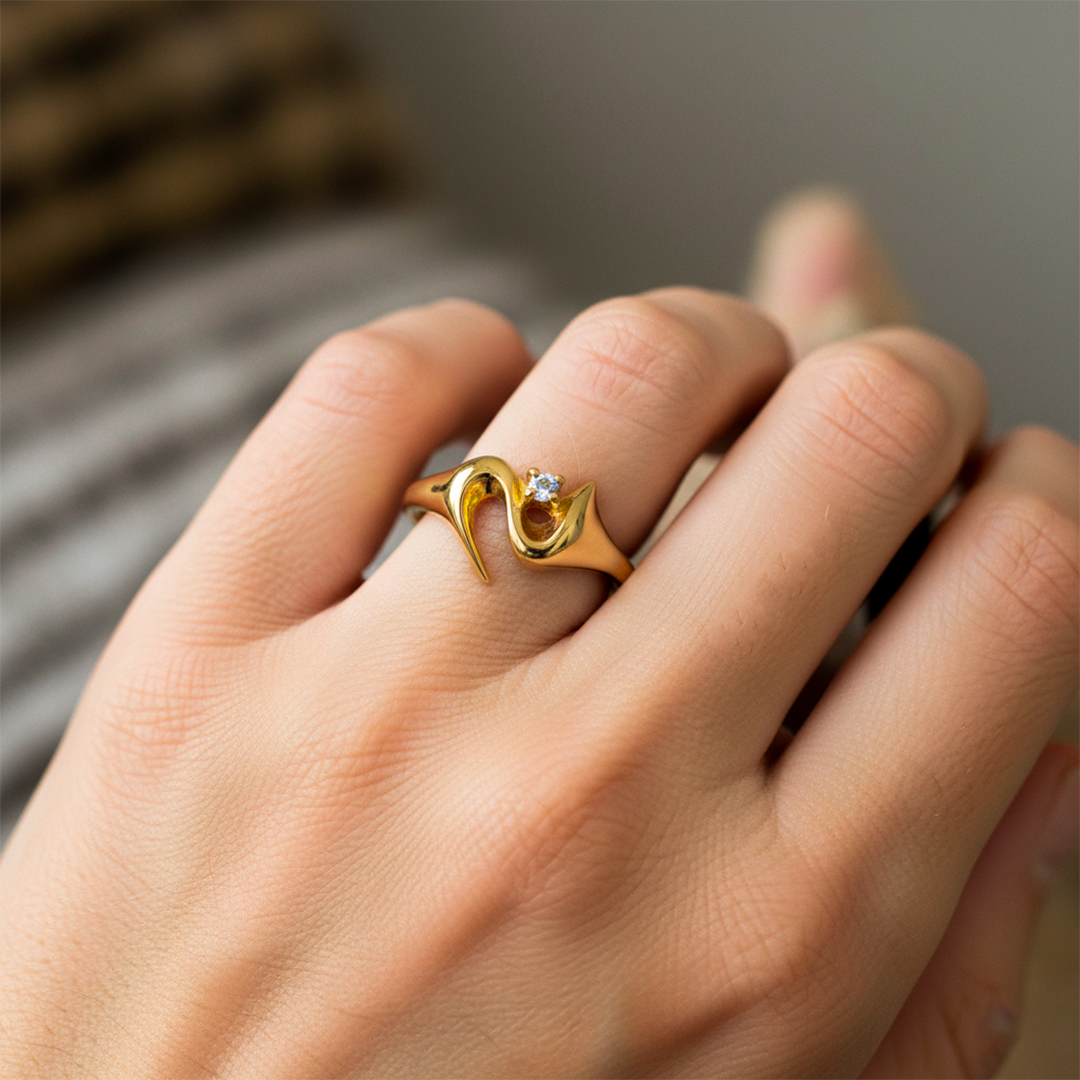 Mano de mujer usando un anillo en oro amarillo de 18 quilates con cristal de color blanco de Joyería Caracas. 