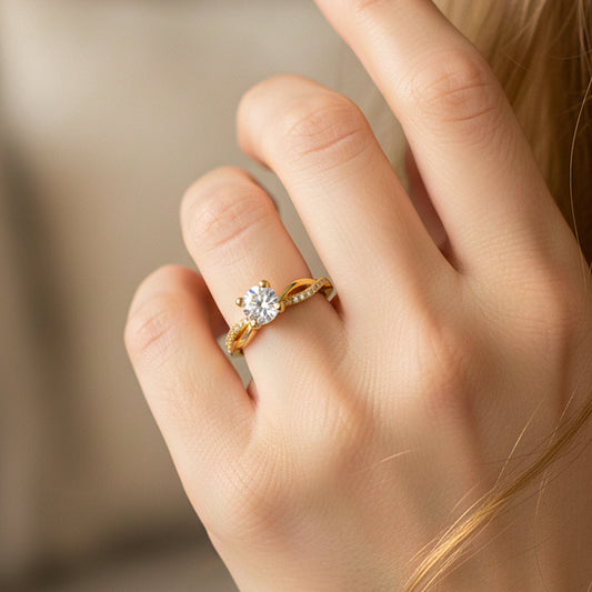 Mano de modelo usando un anillo con forma de infinito en oro amarillo de 18 quilates con cristales de Joyería Caracas. 